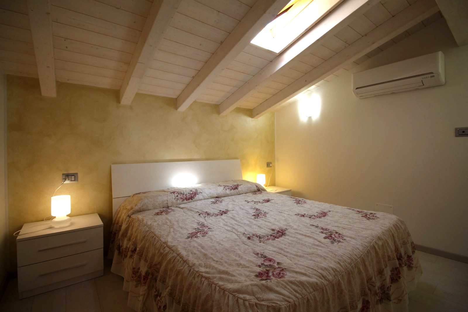 Doppelzimmer mit weißen Sichtbalken und Dachfenster