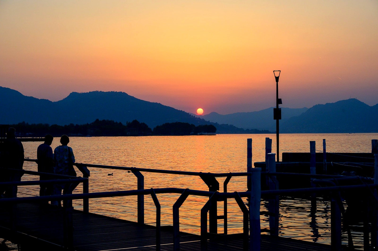 Coppia al tramonto sul pontile del Lago d'Iseo