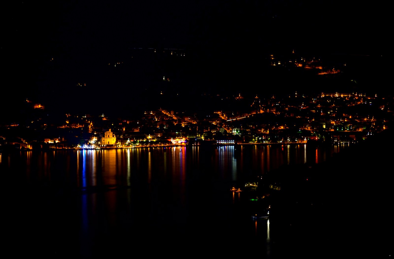 Iseo di notte con riflessi colorati sull'acqua