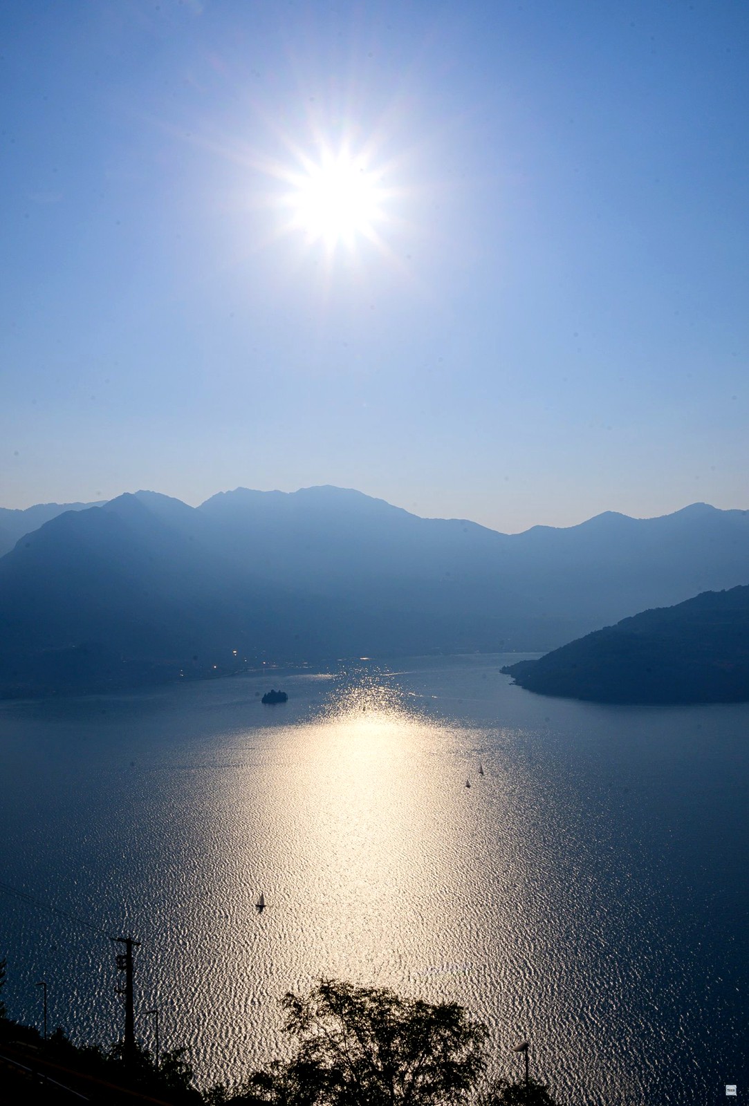 Sole a stella sul lago con barche a vela
